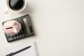 Flatlay view photo of mug of espresso calculator with piggybank and spiral notebook isolated white wooden backdrop