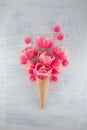 Flatlay waffle sweet ice cream cone with pink tulips blossom flowers over white wood background Royalty Free Stock Photo