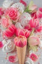 Flatlay waffle sweet ice cream cone with pink tulips and roses blossom flowers over white wood background, top view Royalty Free Stock Photo