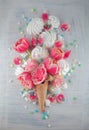 Flatlay waffle sweet ice cream cone with pink tulips and roses blossom flowers over white wood background, top view Royalty Free Stock Photo