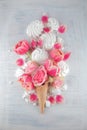 Flatlay waffle sweet ice cream cone with pink tulips and roses blossom flowers over white wood background, top view Royalty Free Stock Photo