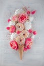 Flatlay waffle sweet ice cream cone with pink tulips and roses blossom flowers over white wood background, top view Royalty Free Stock Photo