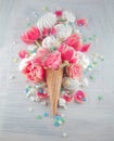 Flatlay waffle sweet ice cream cone with pink tulips and roses blossom flowers over white wood background, top view Royalty Free Stock Photo