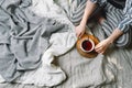 Flatlay of woman holding cup of black tea on a bed Royalty Free Stock Photo