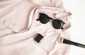 Flatlay women pink shirt, sunglasses, jar with perfume, accessories