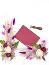 Flatley of natural flowers, burgundy envelope, seal on white background, top view, space for text. Decor, welcome card.