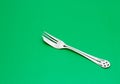 Flatware silver cake fork isolate on green background Royalty Free Stock Photo