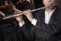 Flautist holding and playing the flute during a performance, close-up Royalty Free Stock Photo