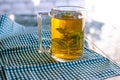 Flavored green tea with mint in a transparent mug. Open-air morning tea Royalty Free Stock Photo