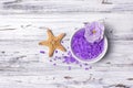 Flavored purple sea salt crystals with violet flower and starfish on white