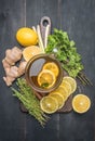 Flavored tea with lemon, and herbs, lined with ingredients, mint, thyme, cinnamon and ginger on a wooden rustic background