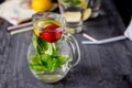 Flavored water with fresh strawberries and mint in glass jars on a black wooden table with bright details.Selective focus, close u Royalty Free Stock Photo