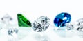 Flawless diamonds, blue sapphire and a green emerald in front of white background Royalty Free Stock Photo