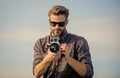 Flawless Moment. macho man with camera. photographer in glasses. travel with camera. male fashion style. looking trendy Royalty Free Stock Photo