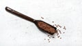 Flax - Linum usitatissimum - seeds in dark wooden spoon on white stone like table Royalty Free Stock Photo