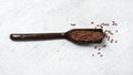 Flax - Linum usitatissimum - seeds in dark wooden spoon on white stone like table Royalty Free Stock Photo