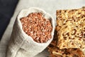 Flax seeds in linen burlap bag with homemade multigrain crispbread Royalty Free Stock Photo