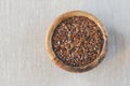 Flax seeds Linum usitatissimum are useful in a bowl of olive wood on flax. Product for beauty and health. Proper nutrition