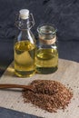 Flax seeds with spoon and linseed golden oil in a glass bottle on the table. Healthy diet with omega 3 fatty acids.