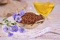 Flax seeds, flax seed oil and flax flowers on a white wooden background. Royalty Free Stock Photo