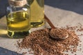 Flax seeds with spoon and linseed golden oil in a glass bottle o