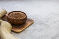 Flax seeds in a wooden bowl on a concrete background, dietary cereal ingredient, cholesterol lowering product, a source of omega-3