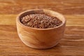 Flax seeds in wooden bowl on rustic wooden background, top view, shallow depth of field