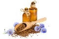 Flax seeds in the wooden scoop, bottle with oil and flowers Royalty Free Stock Photo