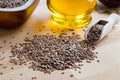 Flax seeds on a wooden table, with flax seed oil in the background Royalty Free Stock Photo