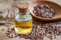 Flaxseed oil in bottle and brown flax seeds on wooden spoon Royalty Free Stock Photo