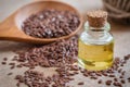 Flaxseed oil in bottle and brown flax seeds on wooden spoon Royalty Free Stock Photo