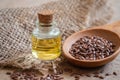 Flaxseed oil in bottle and brown flax seeds on wooden spoon Royalty Free Stock Photo