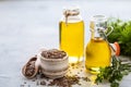 Flaxseed oil in a bottle and ceramic bowl with brown flax seeds and wooden spoon on a white background Royalty Free Stock Photo