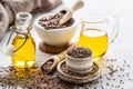 Flaxseed oil in a bottle and ceramic bowl with brown flax seeds and wooden spoon on a white background Royalty Free Stock Photo