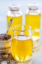 Flaxseed oil in a bottle and ceramic bowl with brown flax seeds and wooden spoon on a white background. vertical Royalty Free Stock Photo