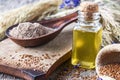Flaxseed oil in a bottle near the chopped flax seeds in a spoon
