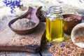 Flaxseed oil in a bottle near the chopped flax seeds in a spoon