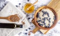 Flaxseed oil in a bottle near the seeds in a spoon. and honey and oatmeal with blueberries on a wooden bowl. Healthy food Royalty Free Stock Photo