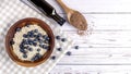 Flaxseed oil in a bottle near the seeds in a spoon ,oatmeal with blueberries on a wooden bowl. Healthy food, copy space Royalty Free Stock Photo