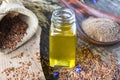 Flaxseed oil in a bottle near flaxseed on a wooden table