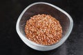 Flaxseeds in a clear glass bowl on a dark table Royalty Free Stock Photo