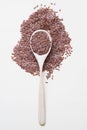 Flaxseeds on wooden spoon on beige background Top view.