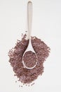 Flaxseeds on wooden spoon on beige background Top view.