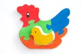 Flay lay of colorful wooden puzzles in shape of chicken on white background.