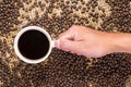 Flay lay style, Male hand holding coffee mug filled with black coffee, Medium dark Roasted peaberry coffee beans bamboo handcraf
