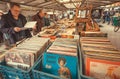 Flea market customer browsing through vintage vinyl music records