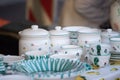 Flea market: Dishes and dinnerware in the foreground, people in the blurry background Royalty Free Stock Photo