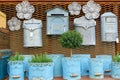 Flea market window shop with gardening decoration - vintage metal flowerpots with herbs and rusty postboxes