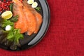 Fled lei. Red fish slices on a black plate with Royalty Free Stock Photo