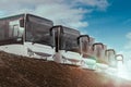 Fleet of buses in a row on a hill in bright sunshine and blue sky Royalty Free Stock Photo